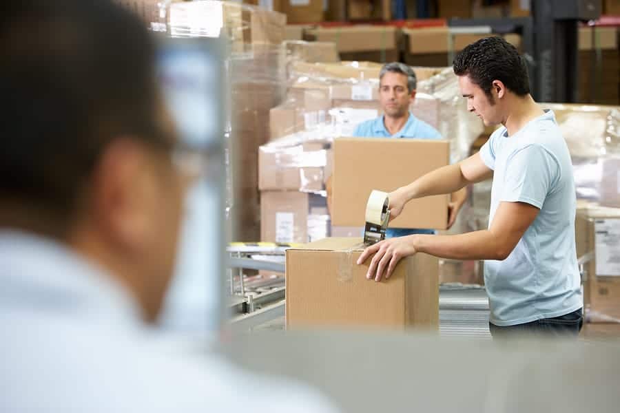Person At Computer Terminal In Distribution Warehouse